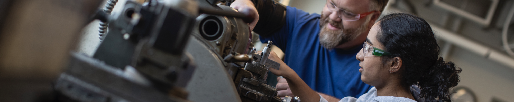 Student working on machine with professor